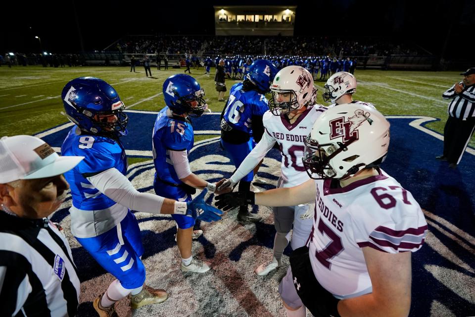 Lewiston High School players greet Edward Little High School, Wednesday, Nov. 1, 2023, prior to a high school football game in Lewiston, Maine. Locals seek a return to normalcy after a mass shooting on Oct. 25. (AP Photo/Matt York)