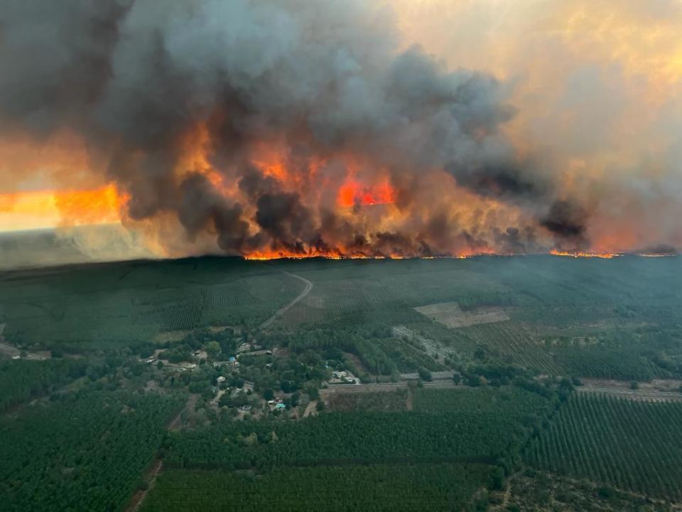 This photo provided by the fire brigade of the Gironde region SDIS 33, (Departmental fire and rescue service 33) shows flames consume trees at a forest fire in Saint Magne, south of Bordeaux, south western France, Wednesday, Aug. 10, 2022. ( SDIS 33 Service Audiovisuel via AP)