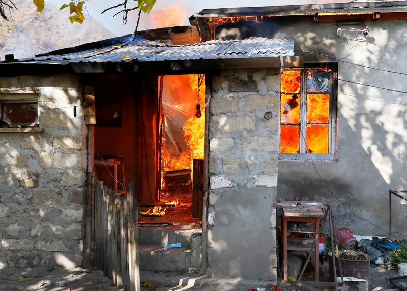 A house is seen set on fire by departing Ethnic Armenians in the village of Cherektar, in the region of Nagorno-Karabakh