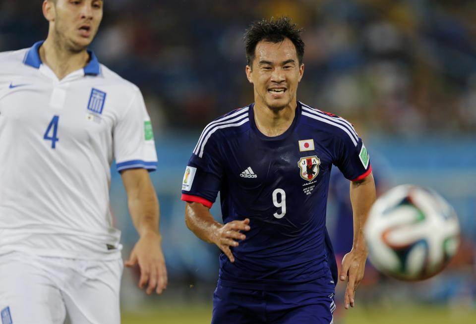 Japan's Shinji Okazaki runs for the ball ahead of Greece's Kostas Manolas during their 2014 World Cup Group C soccer match at the Dunas arena in Natal June 19, 2014. REUTERS/Sergio Moraes (BRAZIL - Tags: SOCCER SPORT WORLD CUP)