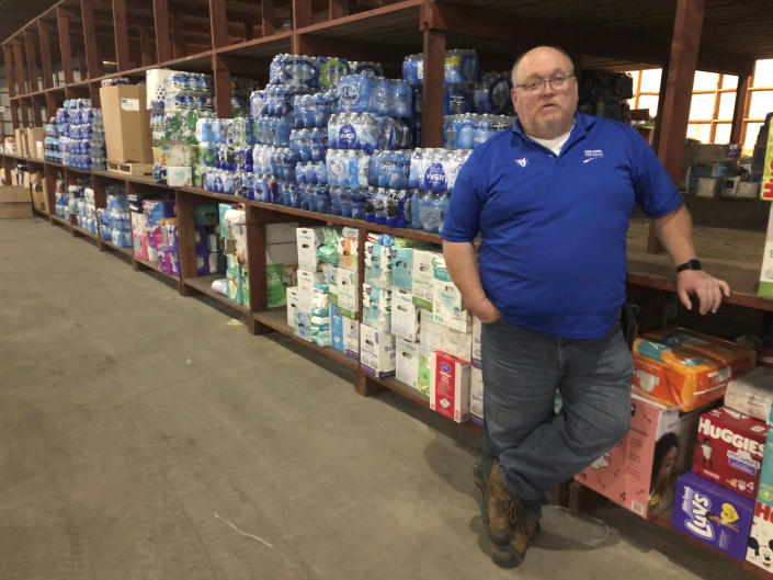 Truck driver Herschel Evans stands near tornado relief supplies in a warehouse on Jan. 10, 2022, in Paducah, Ky. Evans has hauled items such as diapers and paper towels from Atlanta to Kentucky to help with tornado relief and recovery after a December storm struck the state. (AP Photo/Adrian Sainz).