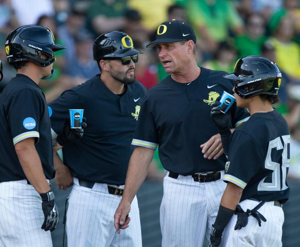 Oregon head coach Mark Wasikowski, center, brings his team together in the 8th inning against Oral Roberts during the NCAA Super Regional at PK Park in Eugene Sunday, June 11, 2023.
