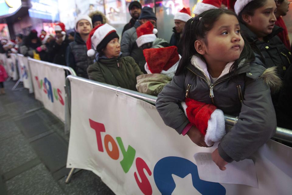 People line up outside before the Toys R Us store opens in Times Square in New York