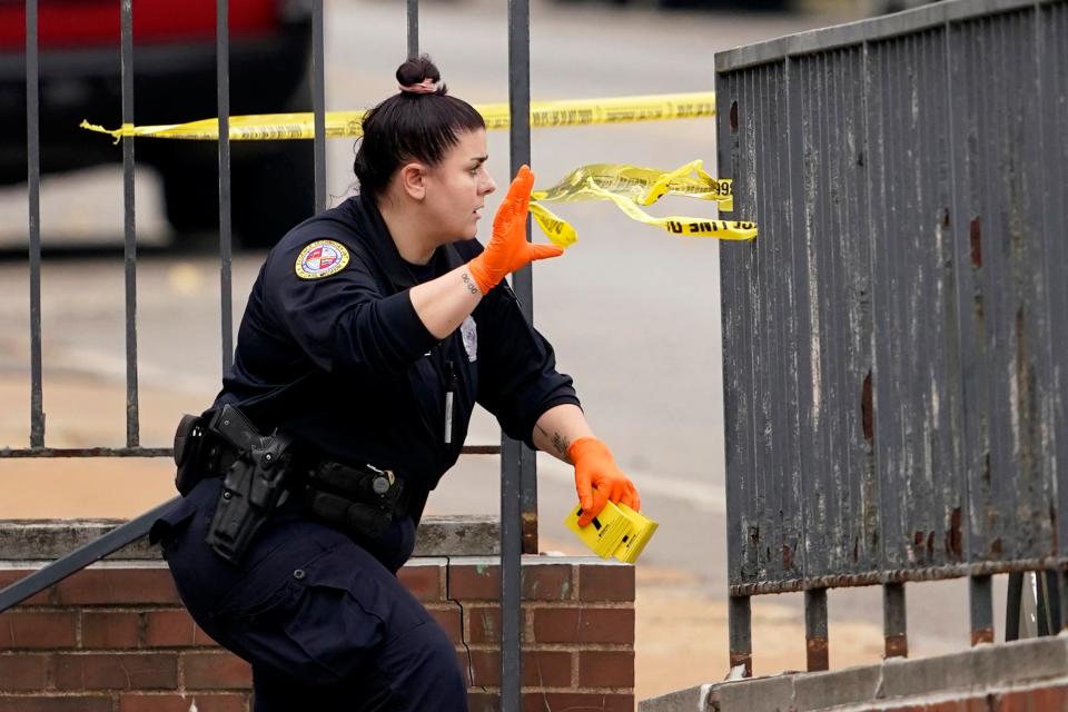 A member of the St. Louis Police Department investigates the scene of a shooting at Central Visual and Performing Arts High School on Monday in St. Louis.