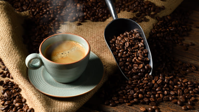 Coffee in cup beside beans