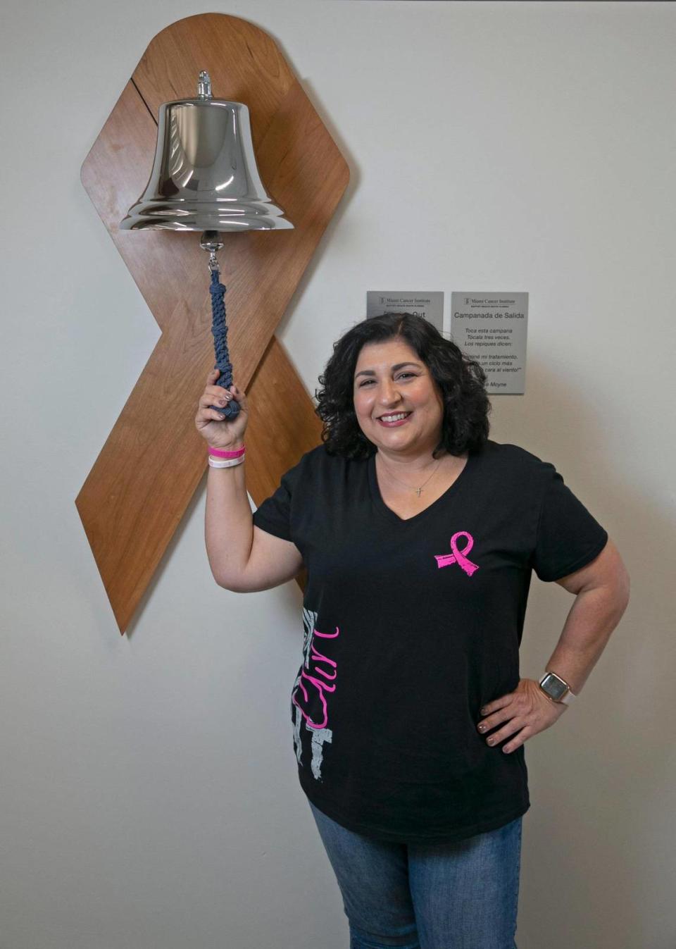 Marlen Acosta-Garcia stands at the bell she rang after her last treatment for breast cancer at Baptist Health’s Miami Cancer Institute Plantation location. Acosta-Garcia is a breast cancer survivor and a patient of Dr. Lauren Carcas.
