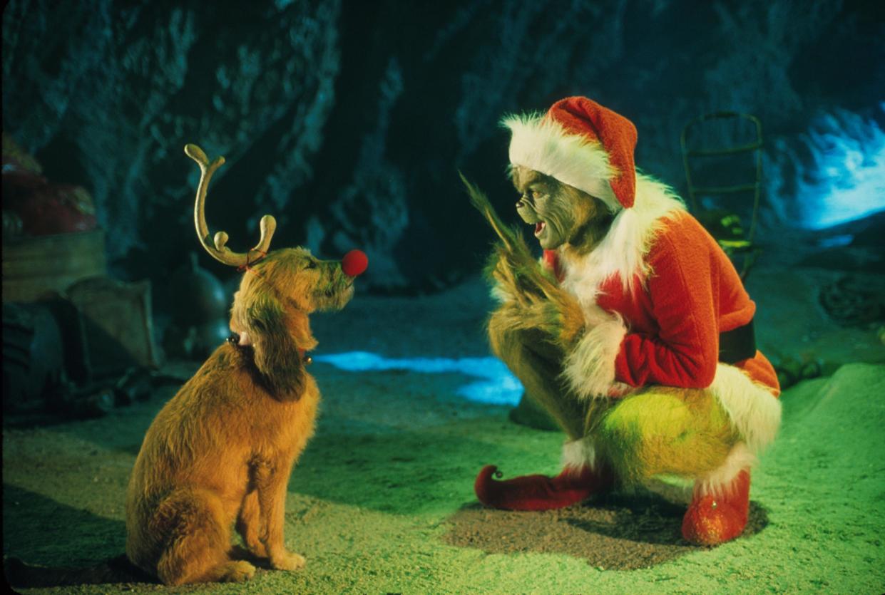 The Grinch, Played By Jim Carrey, Conspires With His Dog Max To Deprive The Who's Of Their Favorite Holiday In The Live-Action Adaptation Of The Famous Christmas Tale, "Dr. Seuss' How The Grinch Stole Christmas," Directed By Ron Howard.  (Photo By Getty Images)