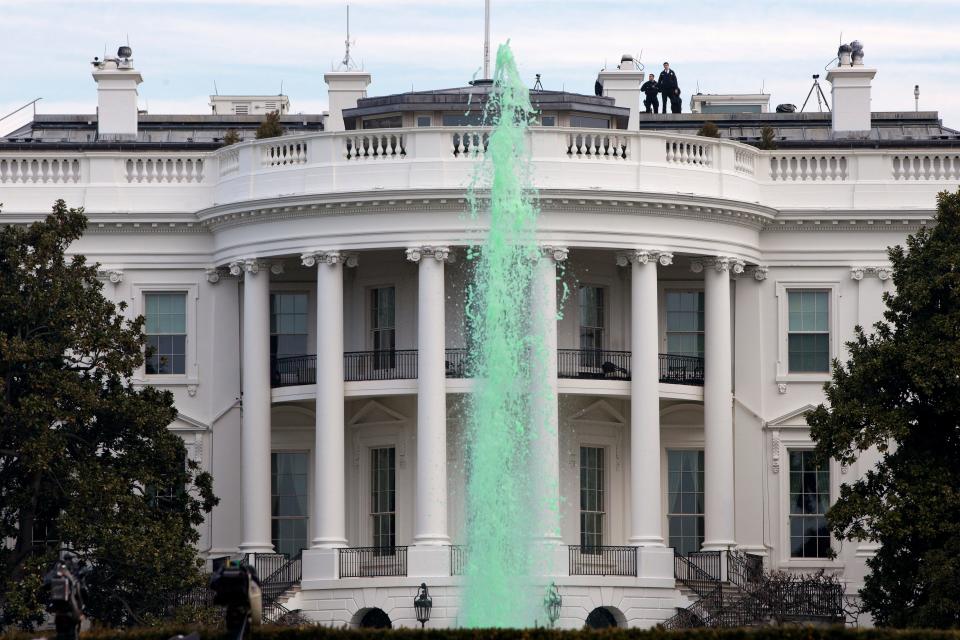 Members of the Secret Service patrol the top of the White House in Washington D.C. March 17, 2015, while a fountain has been dyed green for St. Patrick's Day.