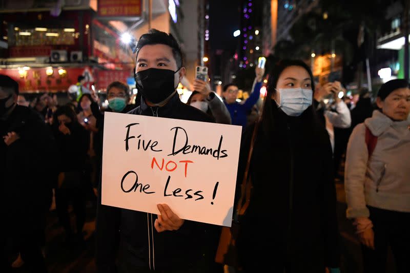 Protester holds a sign during a Human Rights Day march in the district of Wan Chai in Hong Kong