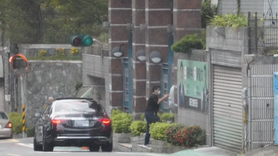 黃承國座車停在萬寧街「仁本禮儀」公司門外，由一名工作人員領他入內。讀者提供