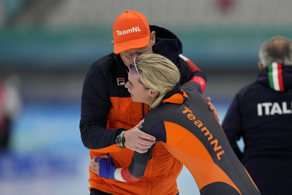 Irene Schouten of the Netherlands reacts with a coach after winning the gold medal and breaking the Olympic record in the women's speedskating 3,000-meter race at the 2022 Winter Olympics, Saturday, Feb. 5, 2022, in Beijing.(AP Photo/Ashley Landis)