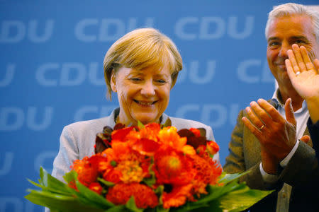 Christian Democratic Union CDU party leader and German Chancellor Angela Merkel receives applause on arrival for a news conference at the CDU party headquarters, the day after the general election (Bundestagswahl) in Berlin, Germany September 25, 2017. REUTERS/Kai Pfaffenbach