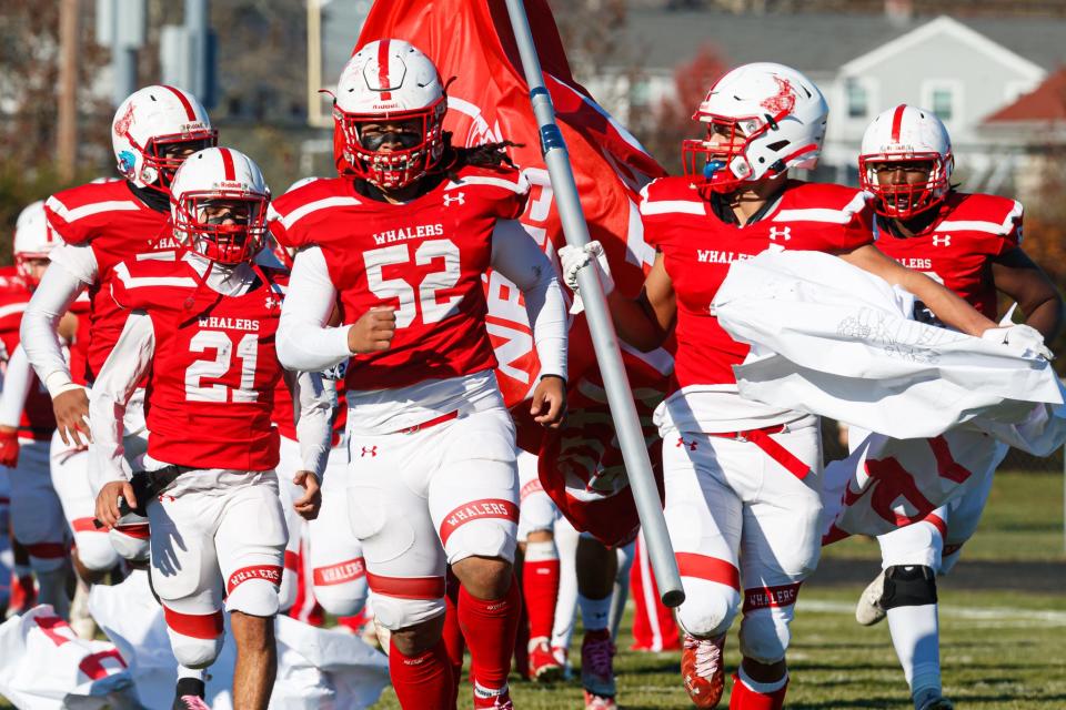 Led by Devin Viera (52), New Bedford takes the field for its Thanksgiving tilt with Durfee. 