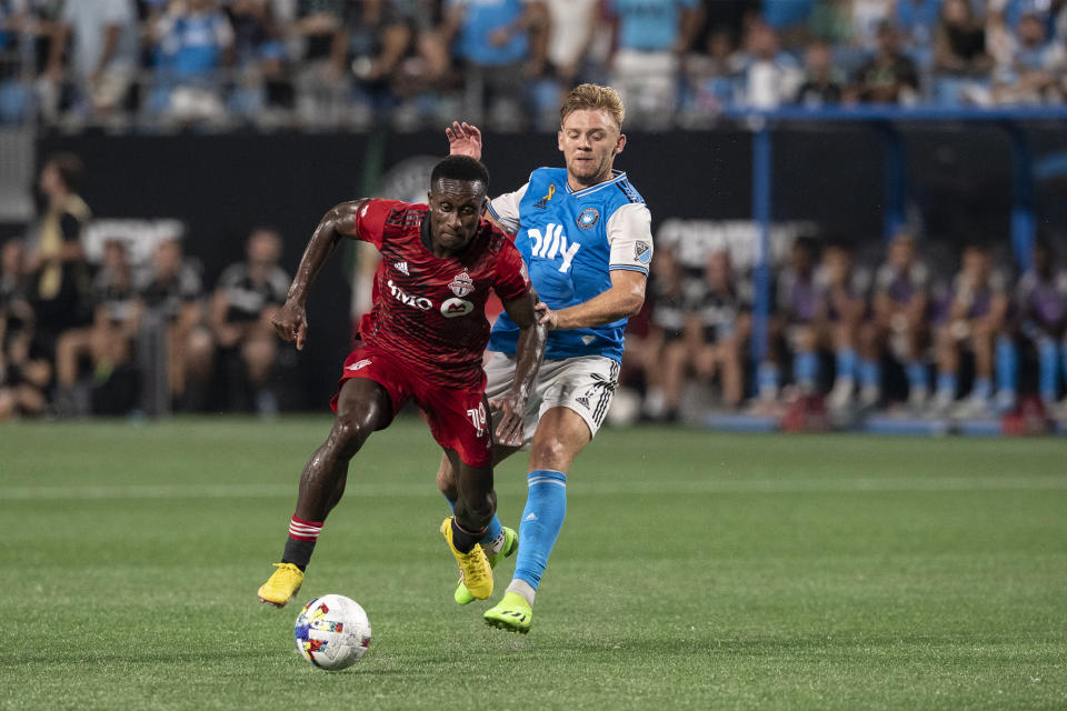 Toronto FC defender Richie Laryea and Charlotte FC midfielder Kamil Jóźwiak (7) battle for the ball during the first half of an MLS soccer match, Saturday, Aug. 27, 2022, in Charlotte, N.C. (AP Photo/Matt Kelley)