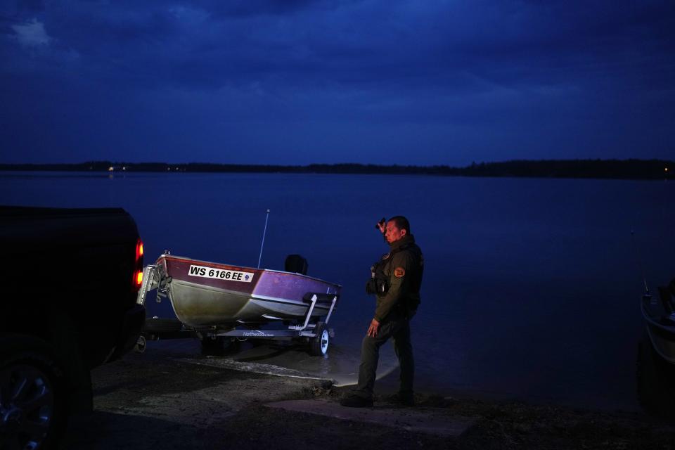 Henry Bearheart, a warden with the Lac Courte Oreilles Band of Lake Superior Ojibwe conservation department, helps guide a boat into the water on Round Lake, Saturday, April 13, 2024, near Hayward, Wis. Wardens often work at boat landings to keep tribal members safe from harassment during the spring spearfishing season. (AP Photo/John Locher)