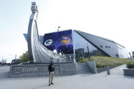 A lone fan has his picture taken in front of U.S. Bank Stadium before an NFL football game between the Minnesota Vikings and the Green Bay Packers, Sunday, Sept. 13, 2020, in Minneapolis. (AP Photo/Bruce Kluckhohn)