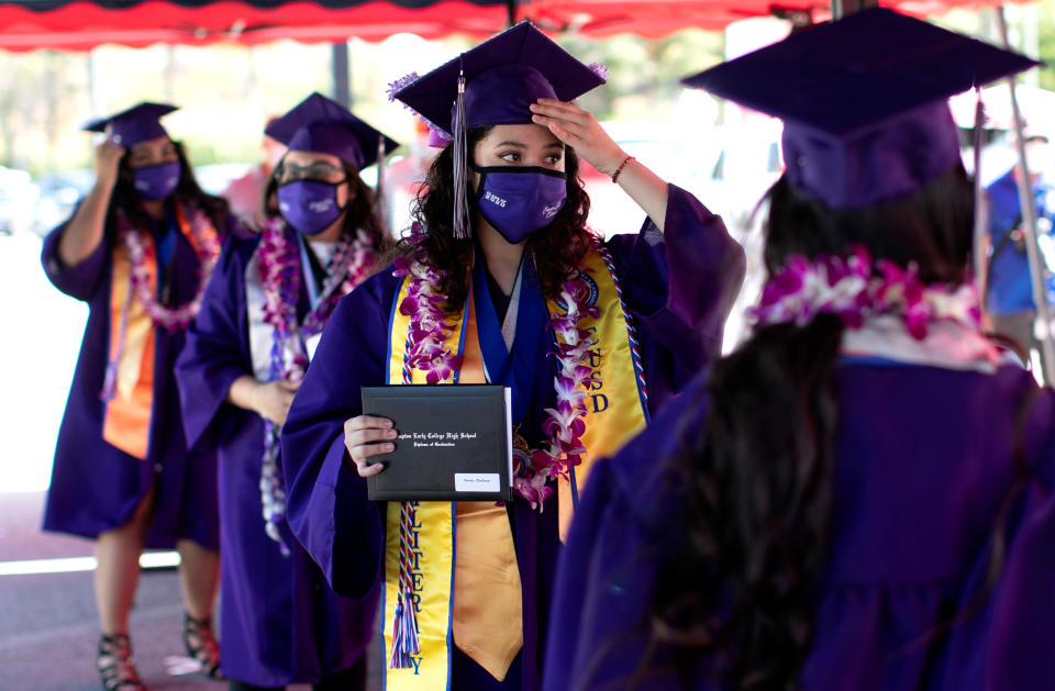 Compton Early College High School graduating student Chelsea Donis adjust her mortar after picking up her diploma in a parking lot during a drive-thru graduating ceremony, during the outbreak of the coronavirus disease (COVID-19) in Compton, California U.S. June 10, 2020. REUTERS/Mario Anzuoni