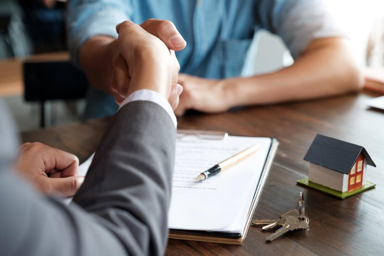 Estate agent shaking hands with his customer after contract signature