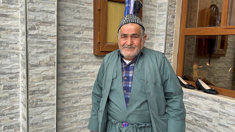 Ramzan Ali, 72, who said he was injured while irrigating his field in Hirure, a few kilometers away from the Turkish border, in June 2021, when a shell from a Turkish outpost crashed into his property, stands in front of his house in Dohuk