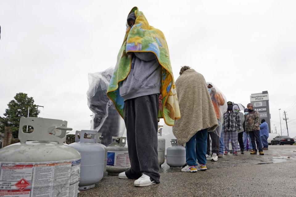 Carlos Mandez waits in line to fill his propane tanks Wednesday, Feb. 17, 2021, in Houston. Customers had to wait over an hour in the freezing rain to fill their tanks. (AP Photo/David J. Phillip)