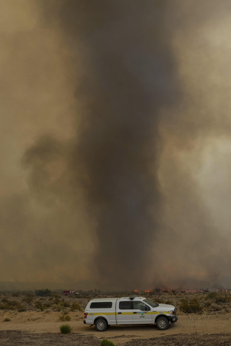 A vortex of ash rises from the York Fire on Sunday, July 30, 2023, in the Mojave National Preserve, Calif. Crews battled “fire whirls” in California’s Mojave National Preserve this weekend as a massive wildfire crossed into Nevada amid dangerously high temperatures and raging winds. (AP Photo/Ty O'Neil)