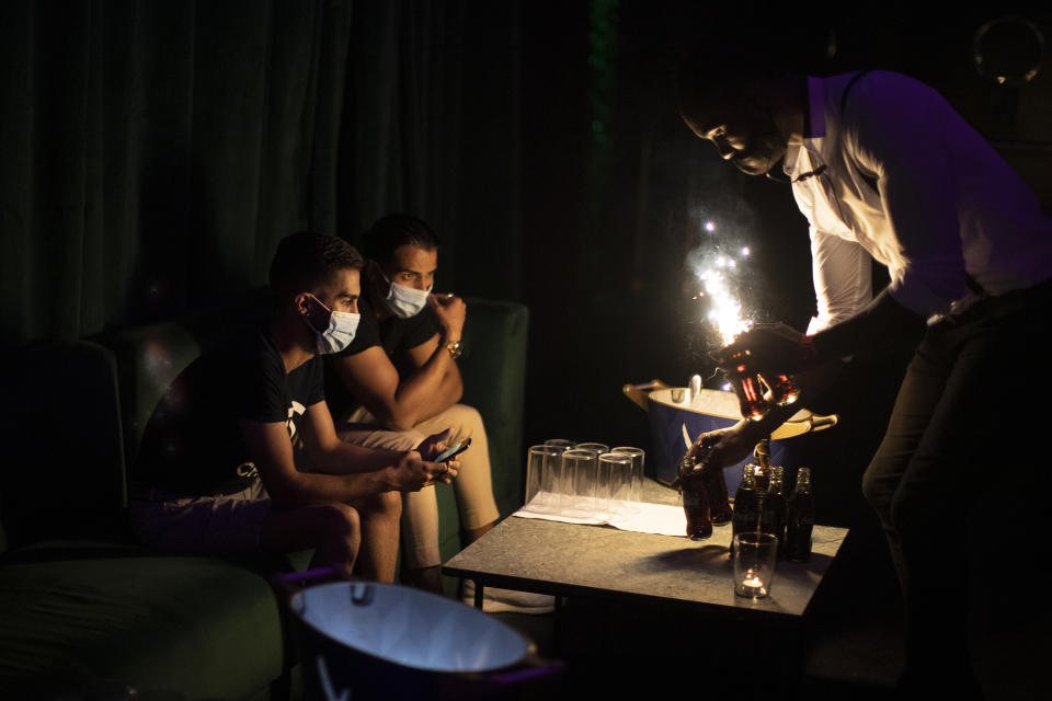 People wearing face masks to prevent the spread of coronavirus gather in a discotheque in Madrid, Spain, early Saturday, July 25, 2020. Nightlife is becoming the new target of Spanish authorities attempting to contain a spike in coronavirus infections since the country ended a lockdown. The Catalonia regional government has shut nightlife venues in Barcelona, and on Friday officials in Madrid said they were considering a similar step. (AP Photo/Manu Fernandez)