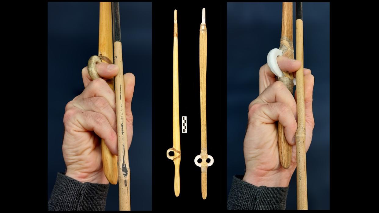  Here we see  a hand clenching around the end of a wooden spear, with the forefinger in the "open ring" finger loop. 