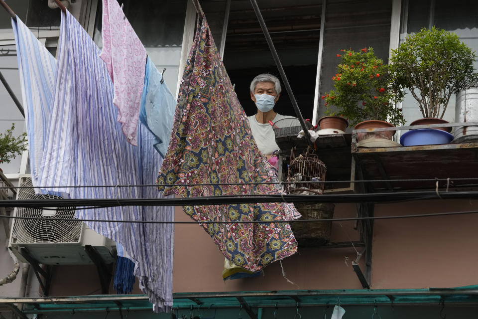 A resident wearing a mask looks out from his home Thursday, June 2, 2022, in Shanghai. Traffic, pedestrians and joggers reappeared on the streets of Shanghai on Wednesday as China's largest city began returning to normalcy amid the easing of a strict two-month COVID-19 lockdown that has drawn unusual protests over its heavy-handed implementation. (AP Photo/Ng Han Guan)