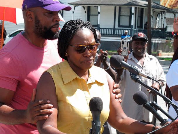 PHOTO: Wanda Cooper Jones, the mother of Ahmaud Arbery, is held by her attorney, Lee Merritt, while addressing supporters gathered for the unveiling of new street signs honoring Arbery, Aug. 9, 2022, in Brunswick, Ga. (Russ Bynum/AP)