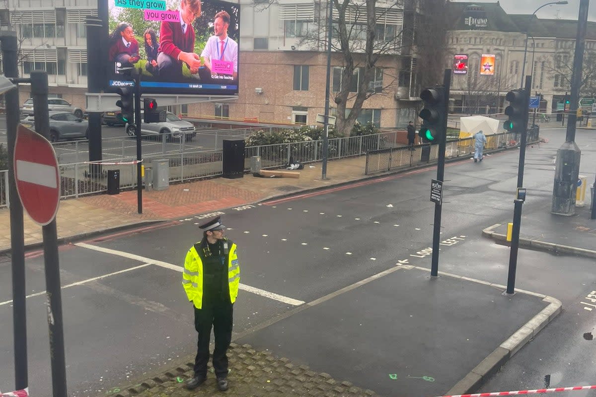 A police officer guards a taped off area following the shooting in Catford Broadway  (James Prescott-Kerr)