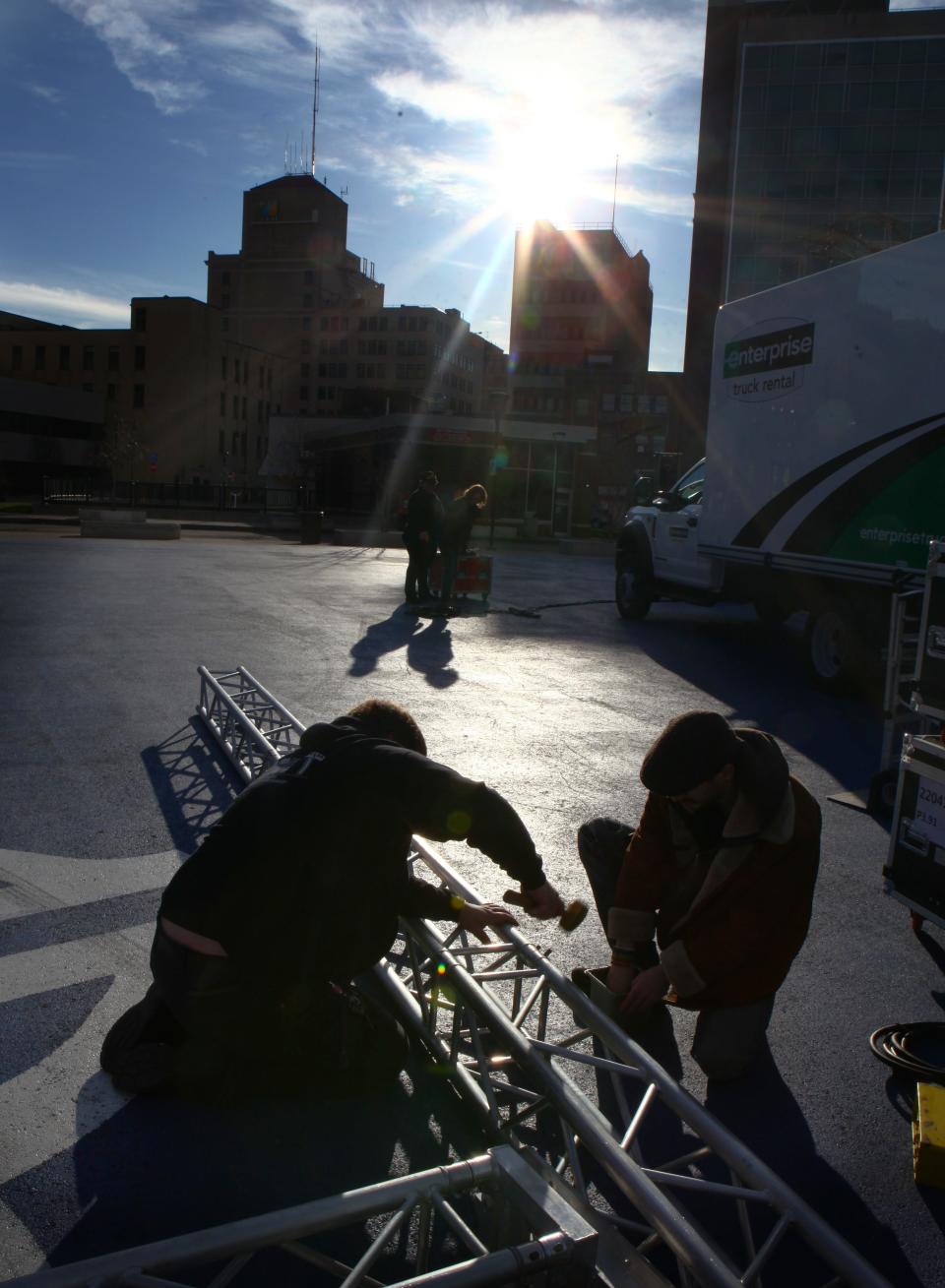 Under full sun, Creighton Lowe and Zach Werner, of Hamilton AV, work to install a video screen on Parcel 5 Monday morning. The 16X9 foot screen will be used to stream the solar eclipse later in the day.