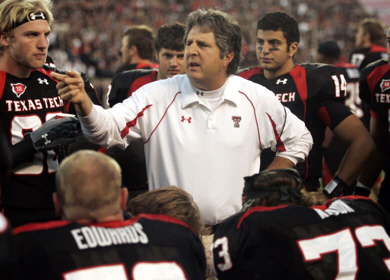 Mike Leach is shown talking with Texas Tech players on the sidelines during a 2009 game