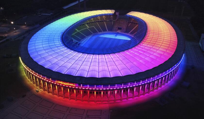 The rainbow-illuminated Olympic Stadium is pictured in Berlin, Germany, Wednesday, June 23, 2021. Scars of World War II and relics from its Nazi past are preserved at Berlin's Olympiastadion. When Spain plays England in the European Championship final, they will be playing in a stadium that doesn't hide it was built by the Nazis for the 1936 Olympic Games. (AP Photo/Michael Sohn)