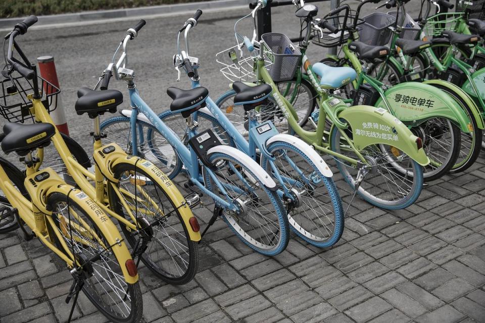 Ofo Inc., left and second left, Xiaoming Danche, third and fourth left, and other bicycles stand parked on a sidewalk in Shanghai, China, on Thursday, May 25, 2017. In China, Qilai Shen/Bloomberg