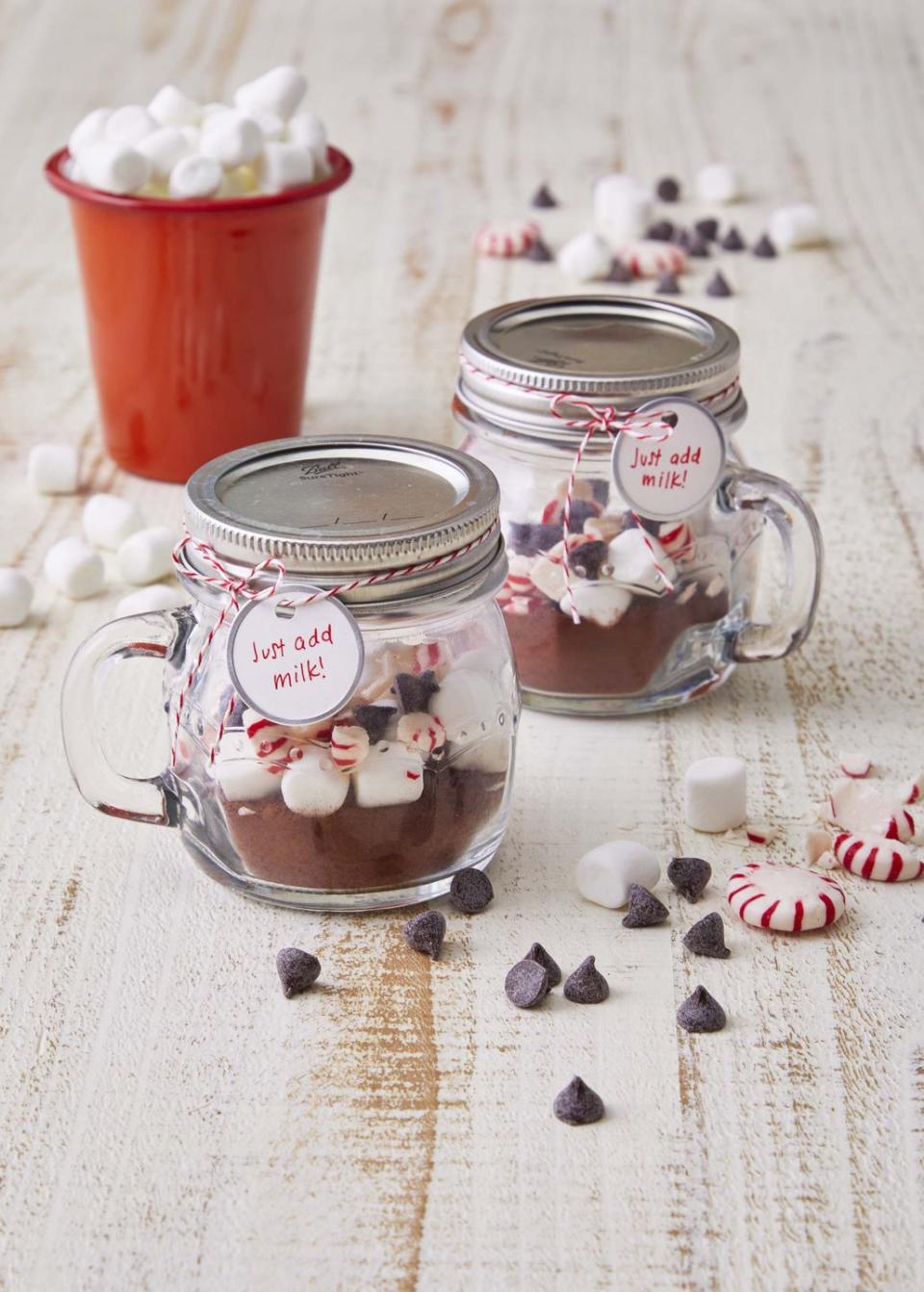 mini mug mason jars filled with hot chocolate mix and topped with chocolate chips mini marshmallows, and broken starligh mints