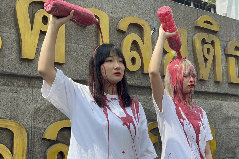 Political activists Orawan Phuphong, left, and Tatawan Tuatulanon, pour red liquid over their heads in protest outside the Criminal Court in Bangkok, Thailand, Monday, Jan. 16, 2023. Concerns about the condition of the two activists currently on hunger strikes seeking political and judicial reforms heightened Monday, Feb. 6, 2023, after the hospital where the two women are being kept urgently summoned their parents. (Ratsadon News via AP)