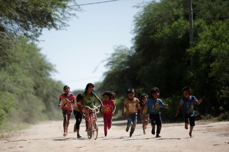 Children of the indigenous Wichi community run while playing, in the Salta province