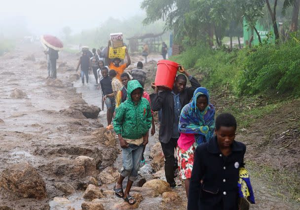 PHOTO: Locals in the Chiradzulu district walk with their salvaged possessions to a safer grounds after mudslides and rockfalls in the area caused by the aftermath of Cyclone Freddy in Blantyre, Malawi, March 15, 2023 (Esa Alexander/Reuters)