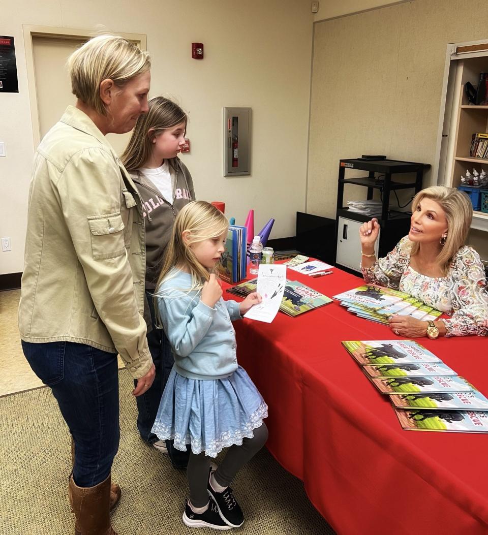 Part-time Coachella Valley resident and author/journalist Janet Zappala speaks to a family at the Palm Valley School Art and Author Night on March 7, 2024, in Rancho Mirage, Calif.