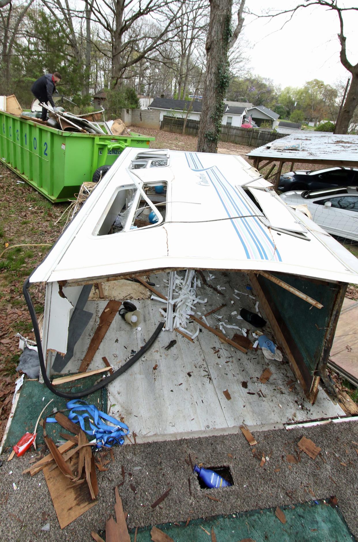 Part of a camper that once stood next to a home on Ferrell Grove Avenue sits now on a trailer as a crew from DEP New Vision work to clean up the debris Tuesday morning, March 26, 2024.