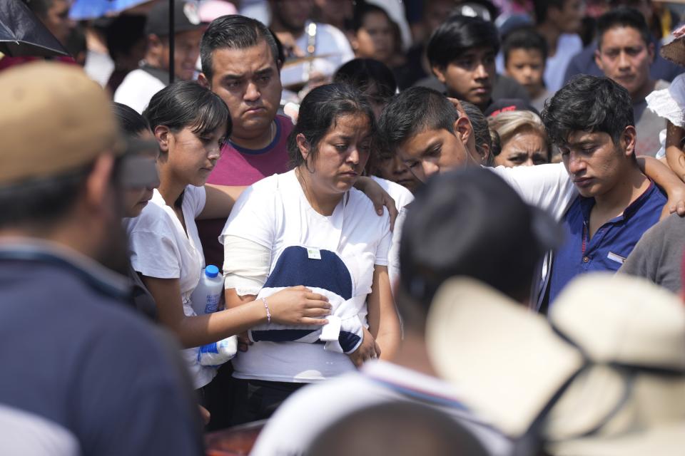 Relatives of a man slain in a mass shooting, attend a burial service in Huitzilac, Tuesday, May 14, 2024. The shooting in the mountain township beset by crime just south of Mexico City resulted in several deaths, authorities said Sunday. (AP Photo/Fernando Llano)