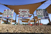 Signs adorn the common area at the Spaces of Opportunity community gardens May 18, 2022, in Phoenix. (AP Photo/Ross D. Franklin)