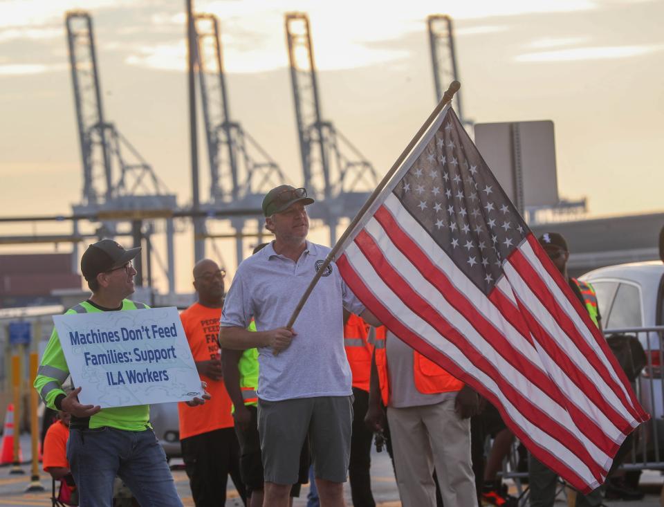 An International Longshoremen's Association (ILA) member holds an American Flag on the picket line on Tuesday, Oct. 1, 2024 as the ILA went on strike at the Georgia Ports Authority in Garden City, Ga.