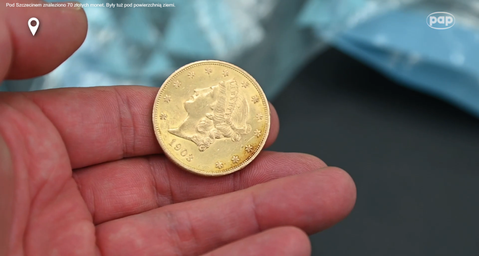 The front of one gold coin showing the year and a woman’s profile.