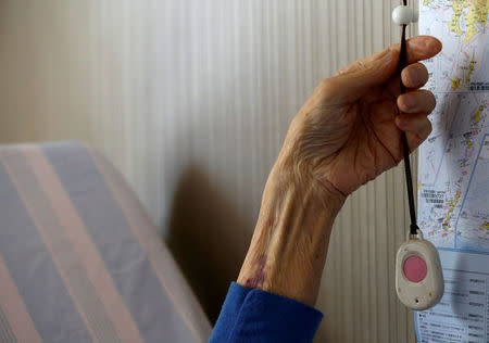 Katsuo Saito, 89, who has leukaemia, holds a personal alarm button which can send an alert to a security company monitoring the aged in Tokyo, Japan, September 8, 2017. REUTERS/Kim Kyung-Hoon