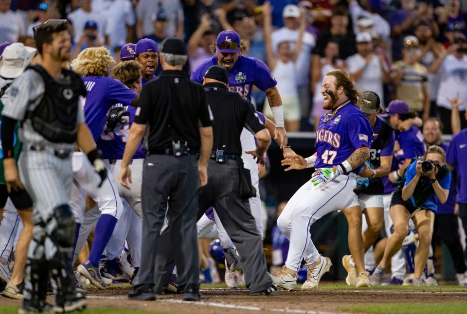 June 22: LSU's Tommy White (47) is greeted at the plate after his game-winning home run against Wake Forest during the 11th inning. LSU won 2-0 to reach the championship series.