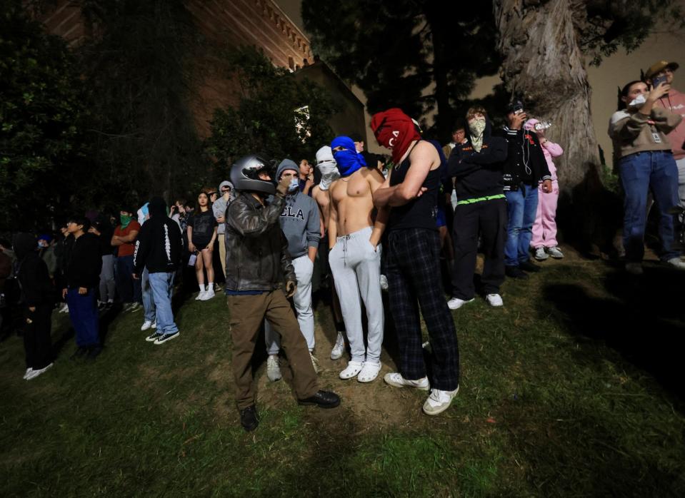 2024年4月30日深夜至5月1日凌晨，加州大學洛杉磯分校內，反對挺巴示威的人站在挺巴者營地附近。路透社