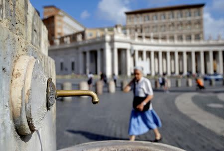 A woman walks next to a fountain in Saint Peter's Square at the Vatican July 25, 2017. REUTERS/Max Rossi