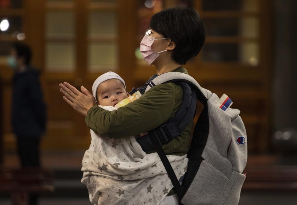 A mother prays with her baby at the Hsing Tian Kong temple in Taipei, Taiwan.