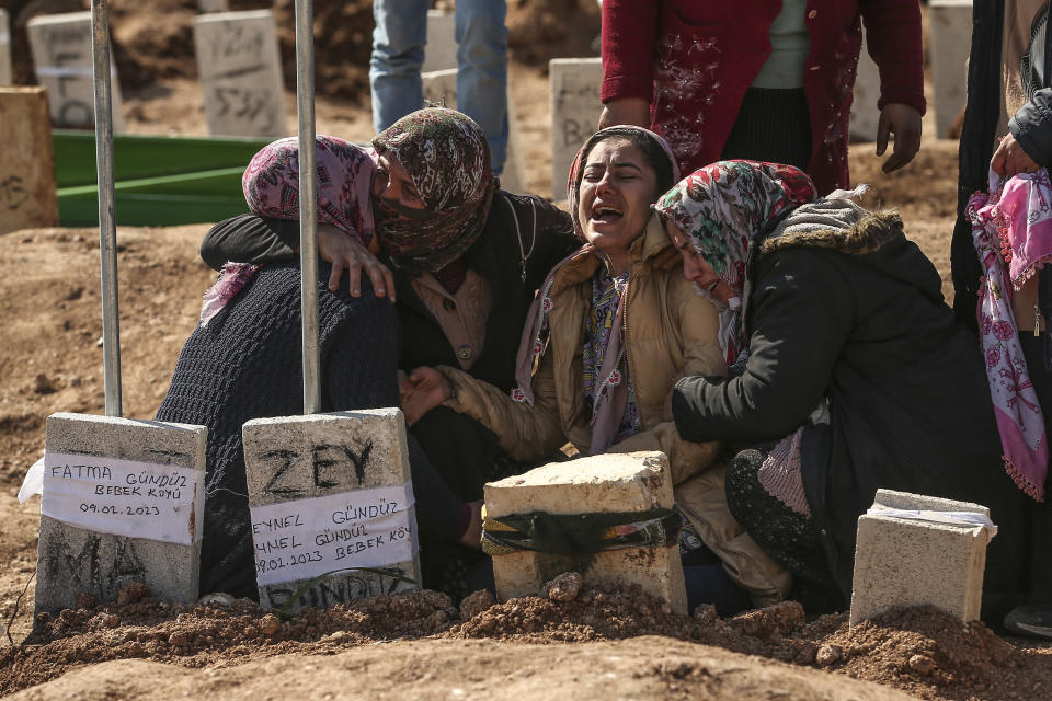 People at the cemetery as they bury their loved ones, victims of Monday earthquake, in Adiyaman, Friday, Feb. 10, 2023. Emergency crews made a series of dramatic rescues in Turkey on Friday, pulling several people, some almost unscathed, from the rubble, four days after a catastrophic earthquake killed more than 20,000. (AP Photo/Emrah Gurel)